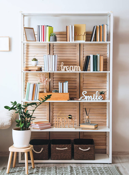 Shelf unit with books and decor in interior of room - Φωτογραφία, εικόνα