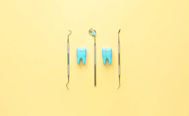 Narzędzia dentystyczne i plastikowe zęby na tle koloru - Zdjęcie, obraz