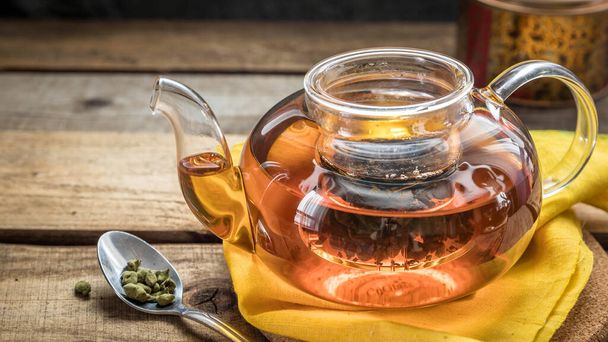 Ginseng-Tee in einer Teekanne. Ginseng Oolong Teegebräu in einem Teelöffel, einer Teekanne auf einem Holztisch.   - Foto, Bild