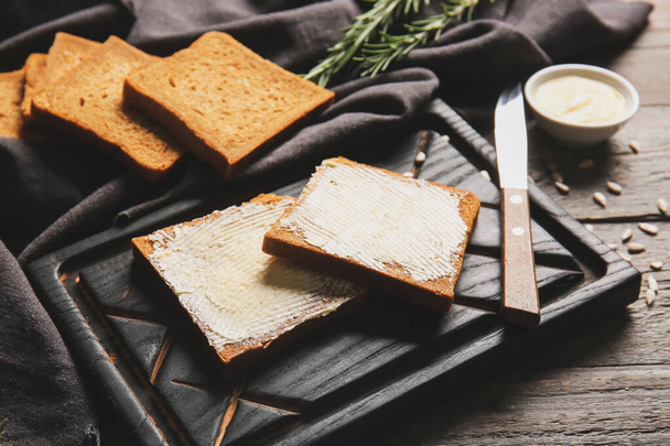 Slices of fresh bread with butter and sunflower seeds on wooden background, closeup - 写真・画像