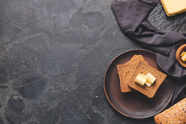 Plate with slices of fresh bread and butter on dark background - Foto, Imagem