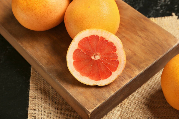 Deska se zralými grapefruity na tmavém pozadí - Fotografie, Obrázek
