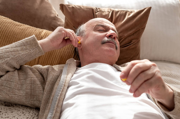 Vezető stresszes férfi kezében egy sárga fülhallgató próbál aludni, amelynek álmatlanság - Fotó, kép