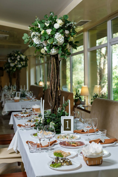Pasgetrouwde tafel decor ingericht in rustieke stijl. Bruiloft decor met bloemen, kaarsen, vetplanten, groen en houten elementen. Natuurthema in decoratie - Foto, afbeelding