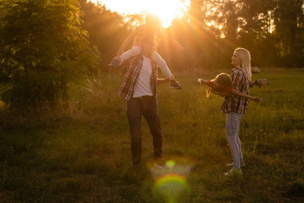 幸せな家族:日没の自然上の母親の父と子供の娘 - 写真・画像