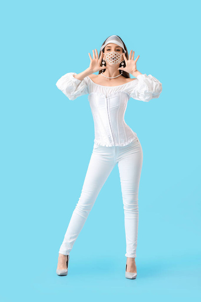Fashionable young woman wearing mask on color background - Φωτογραφία, εικόνα