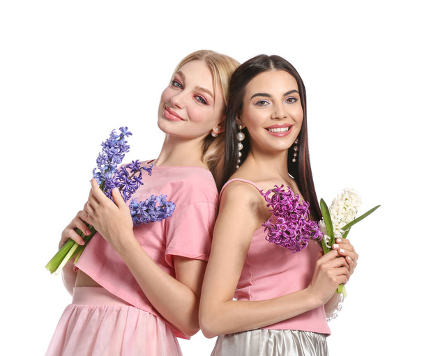 Beautiful young women with hyacinth flowers on white  background - Φωτογραφία, εικόνα