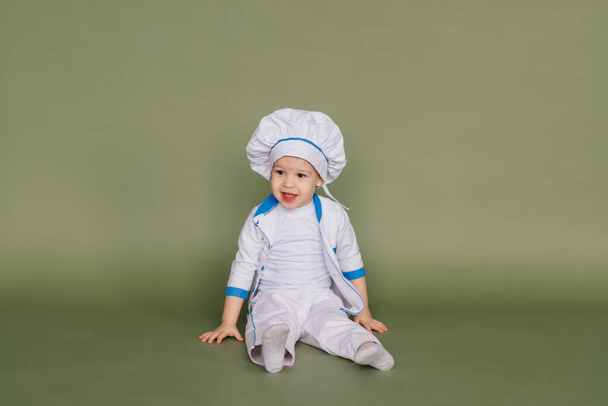 Portrait of a little boy cook holding pan at the kitchen. Different occupations. Isolated over white background. Twin brothers - Photo, Image