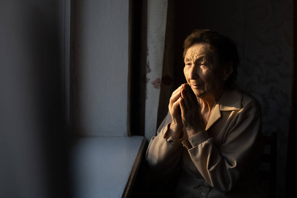 Κοντινό πορτρέτο μιας ηλικιωμένης γυναίκας που προσεύχεται - Φωτογραφία, εικόνα