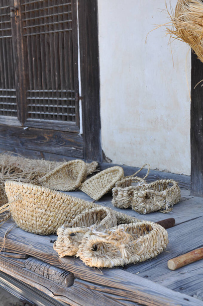伝統的に作られた道具や靴は、韓国の丹東省のホーフォーク村で歴史的なわら織り技術を使用しています - 写真・画像