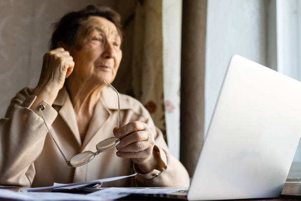 Důchodce čte nespočet dokumentů a je velmi soustředěný. Starší žena doma počítá daně. Žena ve výslužbě počítá účty za domácnost. Pojetí podnikání, úspor, důchodového pojištění, věku a lidí - Fotografie, Obrázek