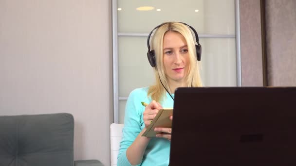 női szabadúszó fejhallgató beszél video chat segítségével laptop. - Felvétel, videó