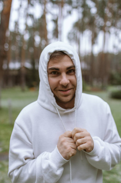 Man in the forest smiling in a white hood - Foto, imagen