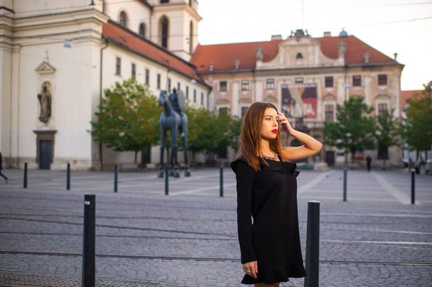 Stylish young girl in a black dress on the street of the city of BRNO in the morning.Czech. - Photo, Image