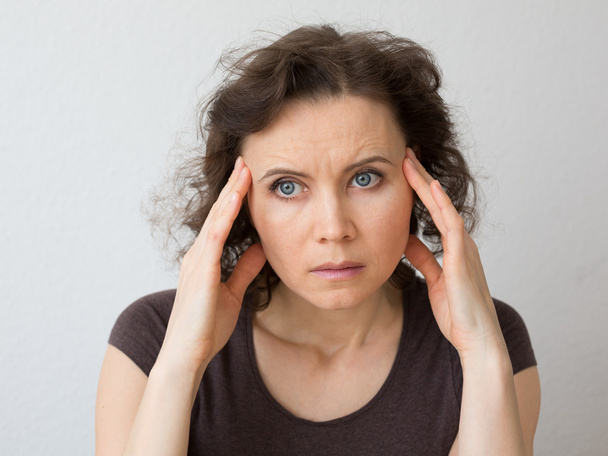 Mujer pensando en serio o con dolor de cabeza
 - Foto, Imagen