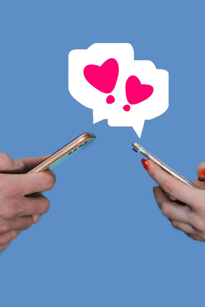 Telefonok egy nő és egy férfi kezében. A pár kommunikál az interneten. Online társkereső. Közösségi hálózati koncepció, szerelem az interneten - Fotó, kép