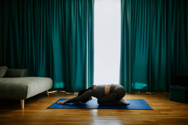 Mujer joven practicando yoga en casa. Práctica de la postura - Foto, Imagen