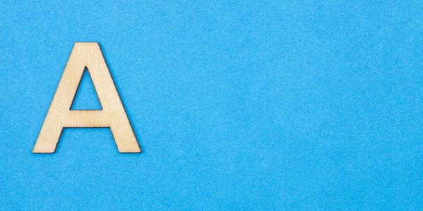 Letter A in wood on blue background - Photo, image