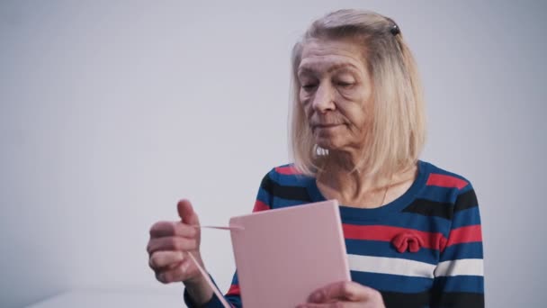 Elderly woman opening her diary and reading from it - Footage, Video