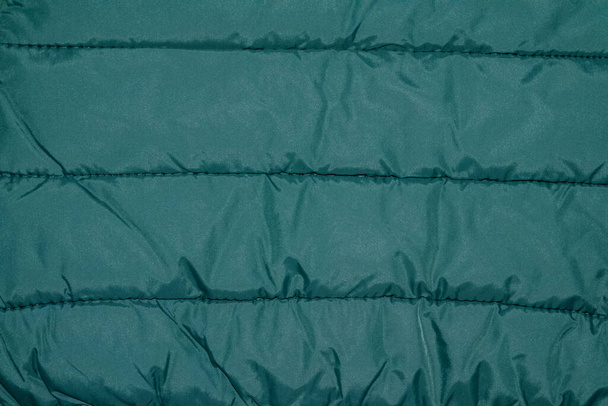 Σκούρο πράσινο νάιλον μπουφάν με οριζόντιες ρίγες. Κλείσε. - Φωτογραφία, εικόνα