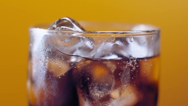 Macro tiro de burbujas y hielo en Cola, gotas de agua que fluyen por el vidrio, chisporroteante vaso de hielo de bebida de espuma.  - Metraje, vídeo