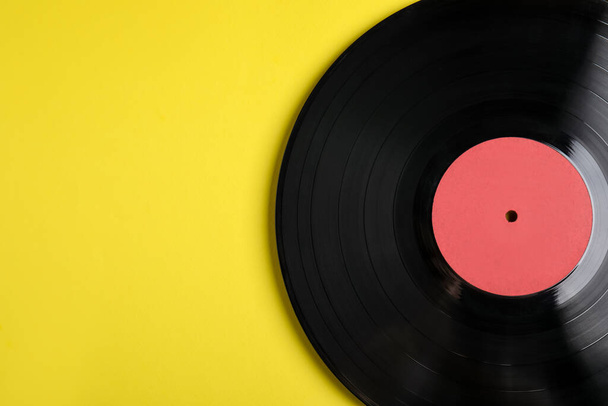 Vintage vinyl record on yellow background, top view. Space for text - Foto, Bild