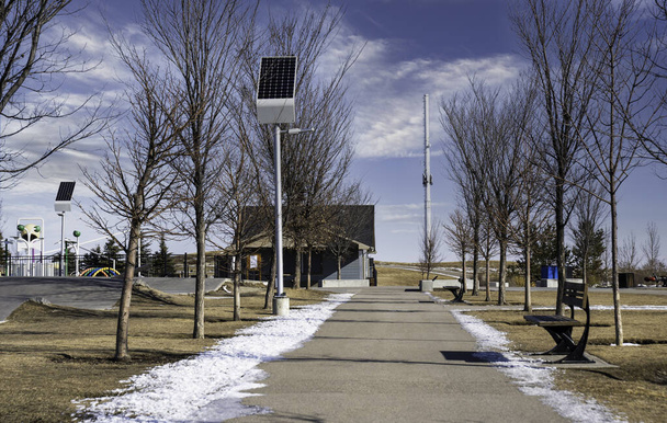 Солнечные батареи заряжают уличные фонари в экологически устойчивом общественном парке в Airdrie Alberta Canada. - Фото, изображение