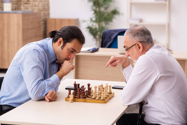 Két üzletember sakkozik az irodában. - Fotó, kép