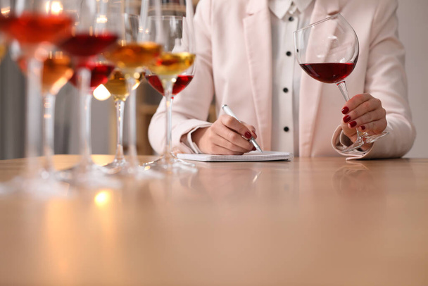 Sommelier tasting different sorts of wine at table indoors, closeup - Фото, изображение
