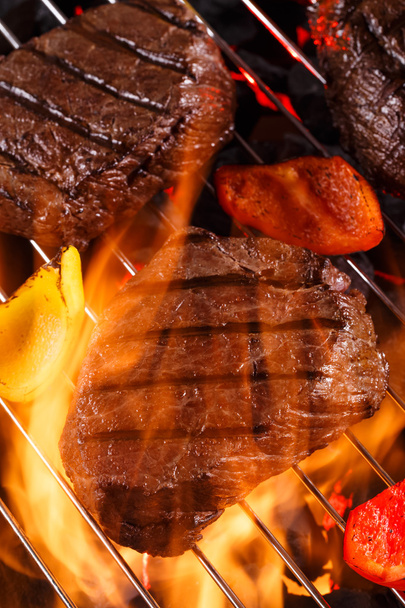 Beef steak on a barbecue grill with flames with vegetables - Foto, Imagem