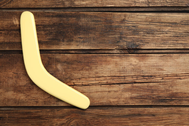 Boomerang on wooden background, top view. Space for text - Foto, afbeelding