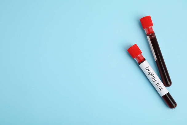 Test tubes with blood samples on light blue background, flat lay and space for text. Doping control - Foto, Imagem