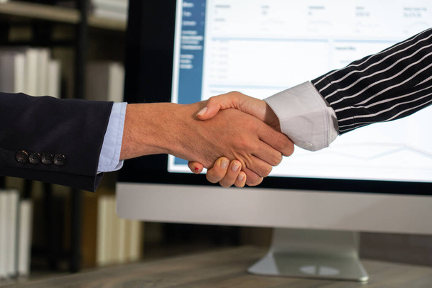 empresária apertar as mãos com o jovem empresário depois de assinar contrato no escritório - Foto, Imagem