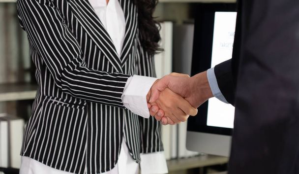 empresaria estrechan la mano con joven empresario después de firmar contrato en la oficina - Foto, imagen