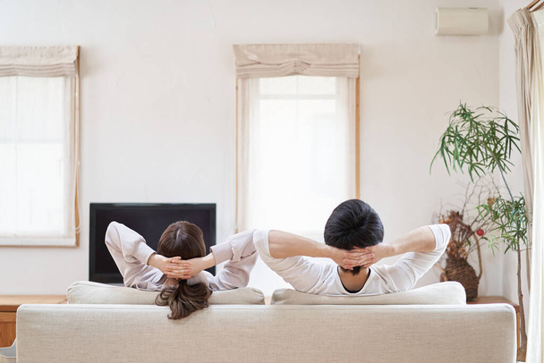 Asian men and women relaxing in the living room - Zdjęcie, obraz