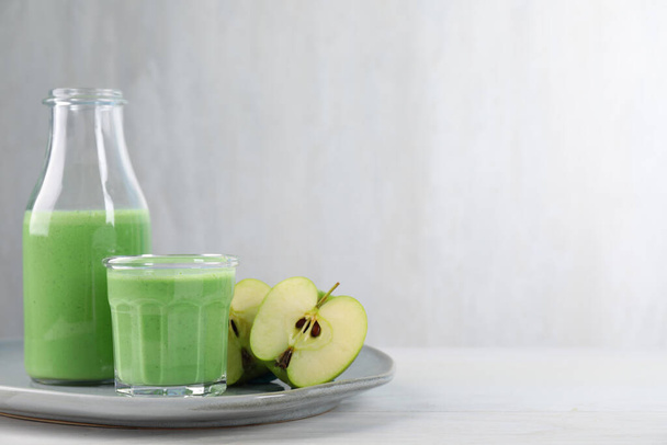 Tasty fresh apple smoothie on white wooden table, space for text - Fotó, kép