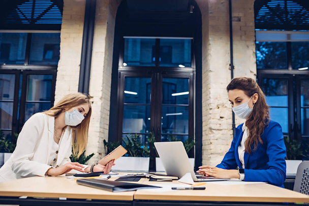 Geschäftsfrauen in medizinischen Masken arbeiten im Büro - Foto, Bild