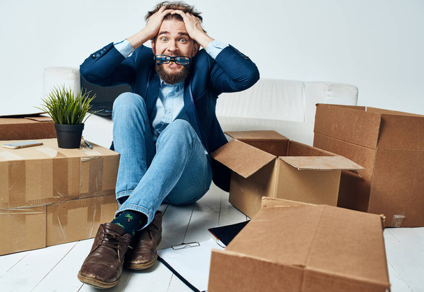 Emotional male manager unpacking lifestyle boxes in office - Foto, Imagem