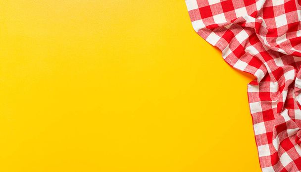 Yellow table covered with red tablecloth . View from top. Empty tablecloth for product montage. Free space for your text - Foto, Imagem