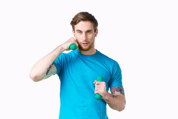 hombre con mancuernas en las manos azul camiseta ejercicio fitness auriculares - Foto, Imagen