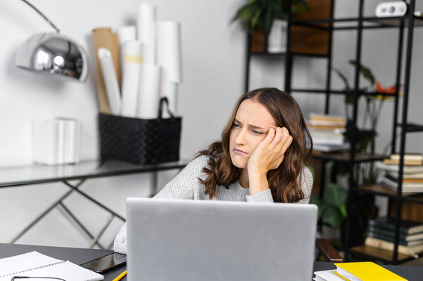 Bored female office employee with a laptop - Фото, зображення