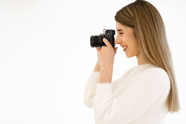 Smiling woman holding camera on white background - Foto, immagini