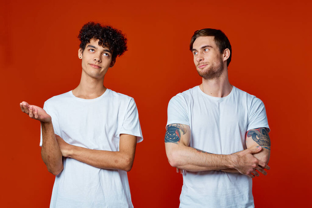 dva přátelé v bílých tričkách stojí vedle sebe izolované pozadí komunikace - Fotografie, Obrázek