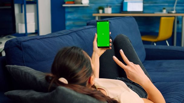 Lässige Frau hält Smartphone mit grünem Bildschirm-Attrappe - Foto, Bild