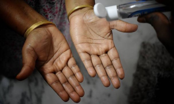 Frauen waschen sich nach der Benutzung einer öffentlichen Toilette die Hände mit Alkohol-Gel oder antibakterieller Seife. Hygienekonzept. Verhinderung der Ausbreitung von Keimen und Bakterien und Vermeidung von Infektionen Coronavirus, Indien. - Foto, Bild