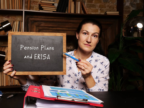 Przystojny bizneswoman pokazujący tablicę z planami emerytalnymi i ERISA. Strzał z bliska. Miękkie skupienie - Zdjęcie, obraz