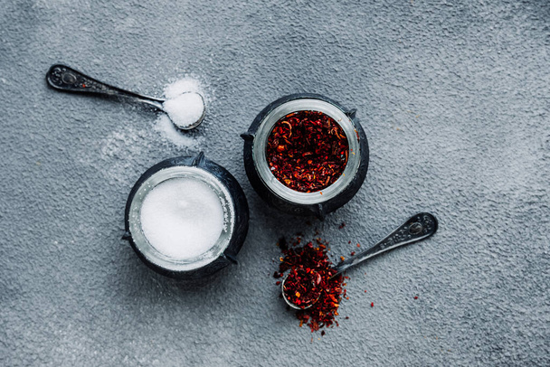 salt and pepper paprika in small oriental-style metal cups and tiny iron dark serving spoons. aromatic spices for cooking, top view, selective focus - Φωτογραφία, εικόνα