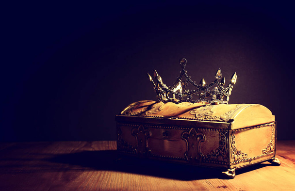 low key image of beautiful queen or king crown over gold treasure chest. vintage filtered. fantasy medieval period - Valokuva, kuva