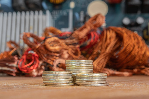 Montones de monedas de oro sobre un fondo de cobre y residuos eléctricos. - Foto, Imagen