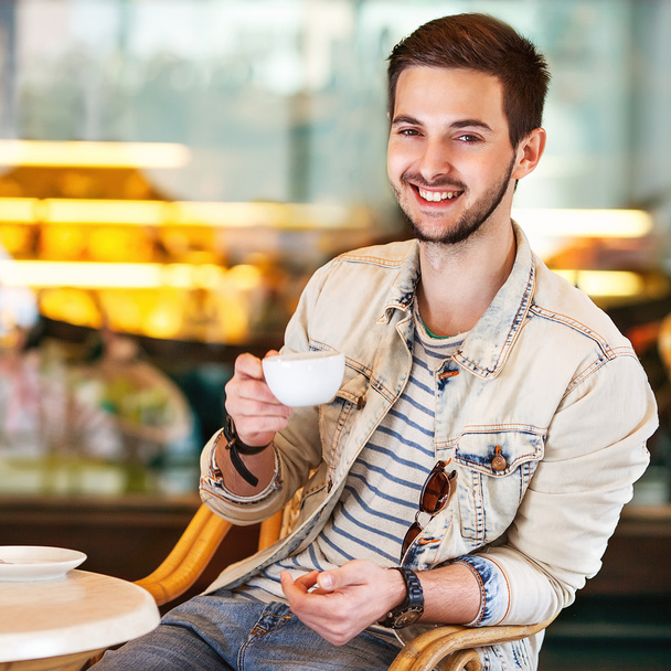 Young fashion man with beard drinking espresso coffee in the cit - Φωτογραφία, εικόνα